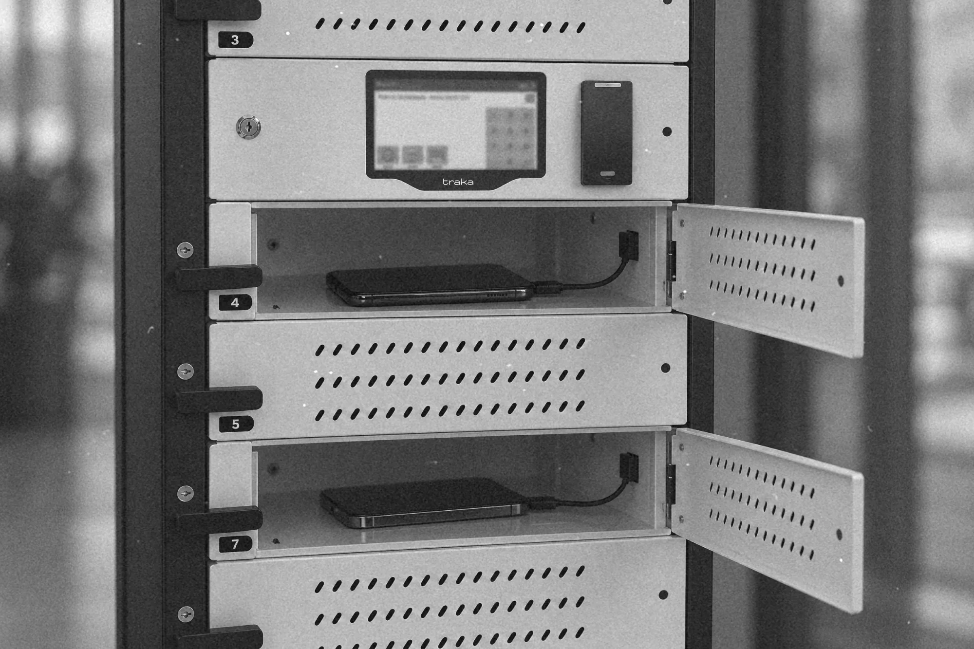 Telefony w osobnych przegródkach szafki depozytowej z kablami ładowania USB